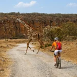 Cyclists riding past Fischer's Tower in Hell's Gate National Park, Naivasha, Kenya