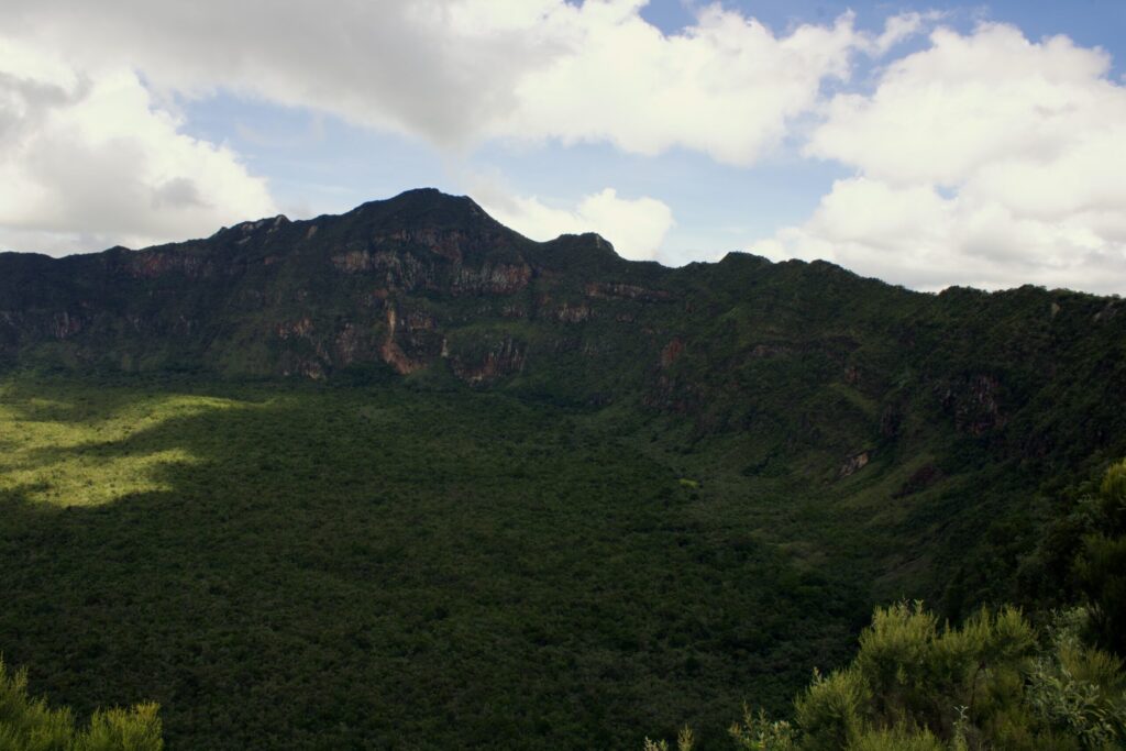 Forested crater floor beneath the steep inner walls of Mount Longonot